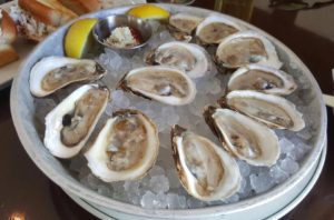 a dozen of fresh oysters served on a plate of cold ice
